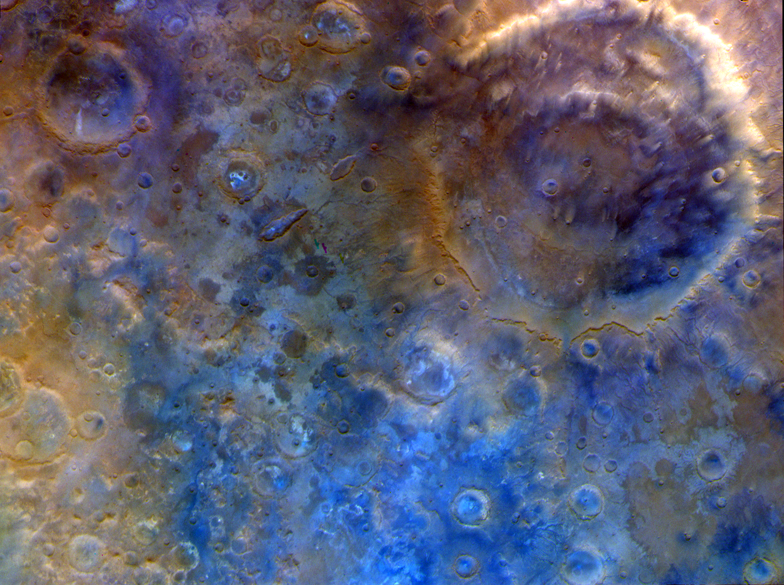 a large double ringed crater surrounded by many other craters in a particularly interesting area of mars.